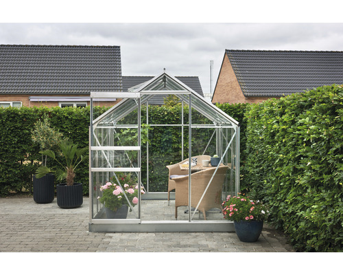 Serre avec plantes et coin salon dans le jardin