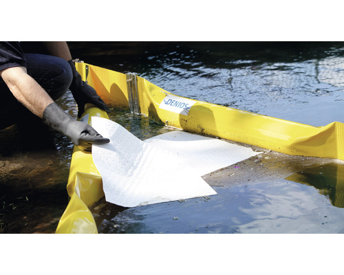 Personne portant des gants plaçant une barrière anti-pétrole et un absorbant dans l''eau
