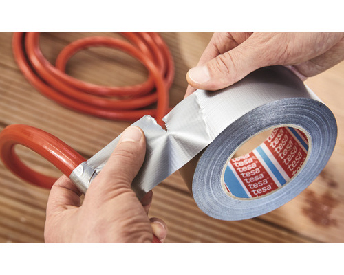 Eine Person repariert einen Schlauch mit Tesa Gewebeband.
