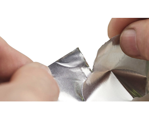 Mains déchirant du papier aluminium