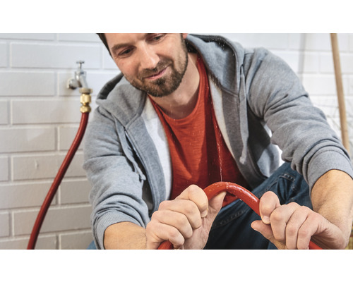 Un homme répare une conduite d''eau qui fuit