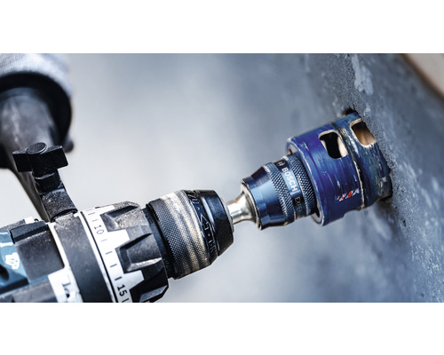 Bohrmaschine mit Bohrkrone bohrt ein Loch in die Wand