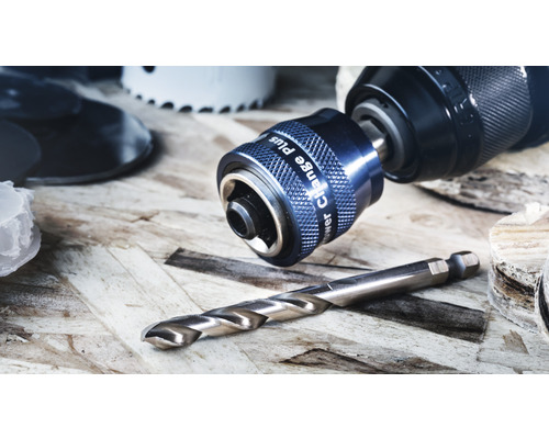 Nahaufnahme einer Bohrmaschine mit Bohrfutter und Bohrer auf einer Holzoberfläche