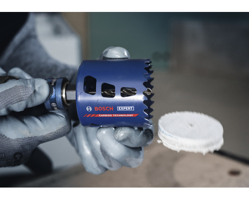 Scie cloche Bosch Expert dans les mains avec des gants de protection.