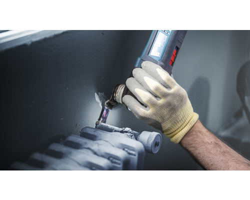 Artisan utilise un outil multifonction sur un radiateur