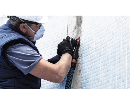 Artisan portant un équipement de protection individuelle travaillant sur les joints de carrelage