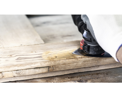 Artisan ponçant du bois avec une ponceuse multifonction.