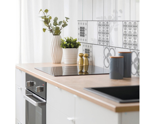 Küchenszene mit Arbeitsplatte, Spüle, Kochfeld, Ofen, Geschirr und Dekor