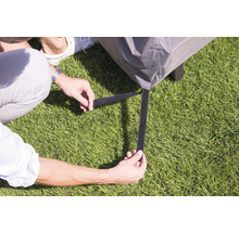 Person befestigt Schutzhülle mit Klettverschluss an einem Gartentisch