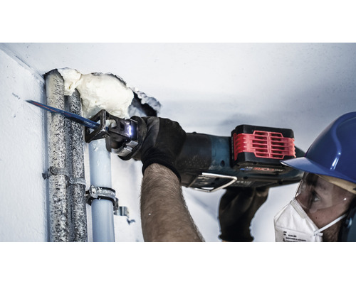 Handwerker schneidet ein Rohr mit einer Säbelsäge