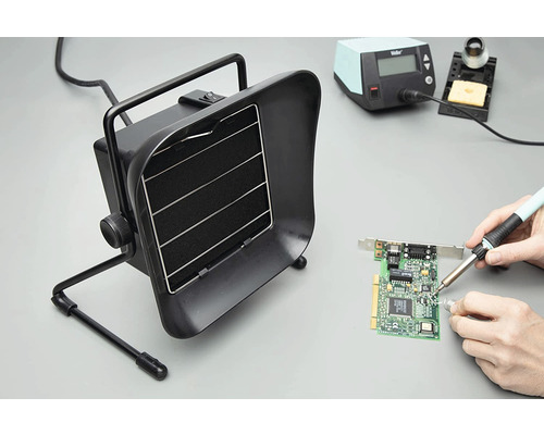 Station de soudage avec dispositif d''aspiration en cours d''utilisation lors du soudage d''une carte de circuit imprimé