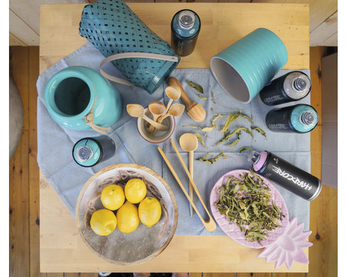 Vue de dessus avec des paniers, des citrons, des cuillères en bois, des plantes et des bombes aérosol sur une table