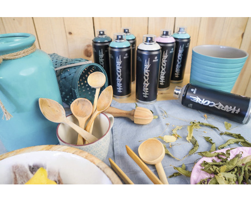 Bombes aérosols Montana Hardcore avec des articles de décoration sur une table