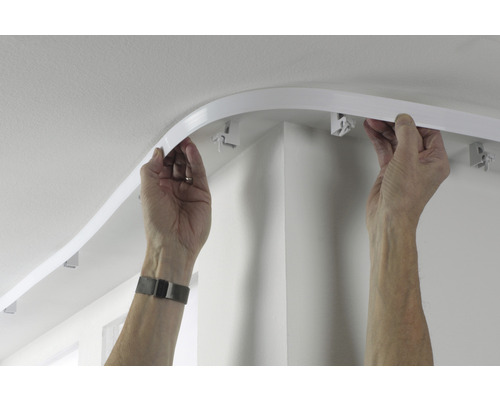 Personne installant un rail de rideau flexible au plafond