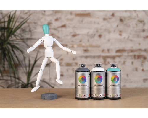 Trois bombes de peinture argentées avec l''inscription Water Based à côté d''un mannequin articulé