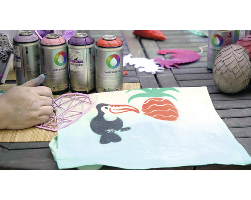 Peinture en aérosol et pochoir lors de la conception d''un tissu avec des motifs tropicaux