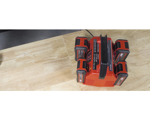 Chargeur de batterie Einhell Power X-Change avec quatre batteries sur une table