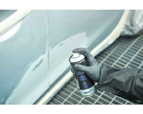 Eine Person grundiert eine Fahrzeugtür mit einer Sprühdose Wash Primer.