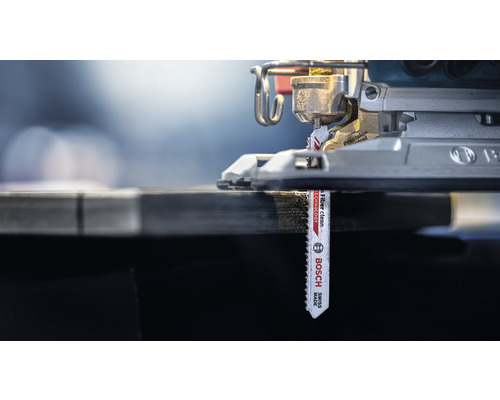 Gros plan d''une scie sauteuse avec une lame de scie insérée coupant du bois