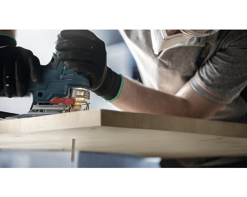 Eine Stichsäge wird zum Sägen eines Holzstücks verwendet.