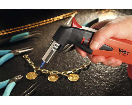 Gros plan d''un chalumeau Weller travaillant sur un bijou, entouré d''outils.