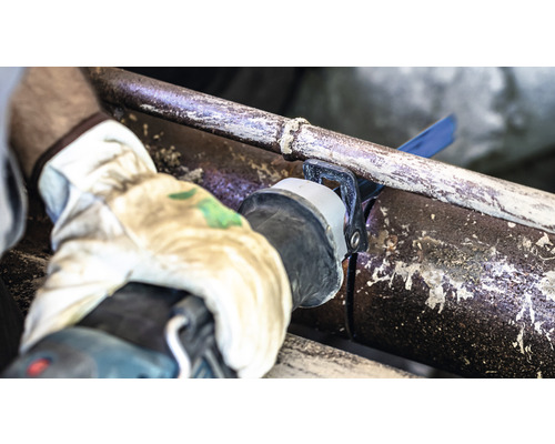 Un tuyau est coupé à l''aide d''une scie sabre.