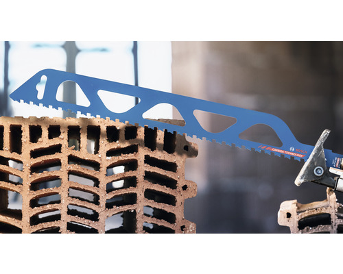 Eine blaue Säbelsäge schneidet einen Lochziegelstein.