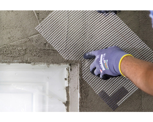 Pose d''une toile d''armature sur un mur enduit