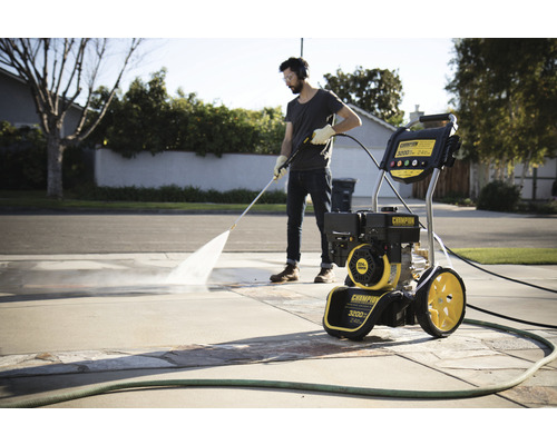 Mann reinigt Auffahrt mit einem Champion Hochdruckreiniger.