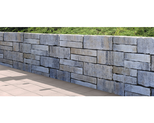 Mauer aus Steinblöcken im Garten