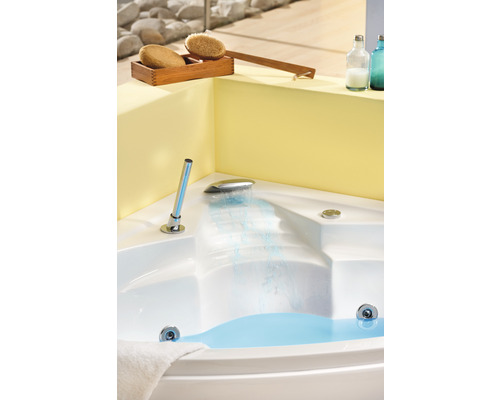 Baignoire d''angle avec eau, robinetterie et accessoires de bien-être dans la salle de bain