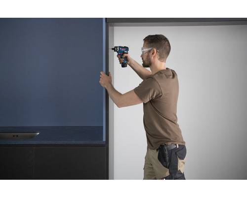 Handwerker montiert Küchenschrank mit Akkubohrer
