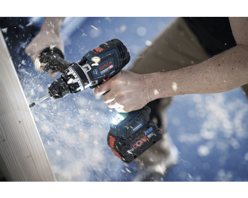 Une personne perce une planche de bois avec une perceuse-visseuse sans fil Bosch.