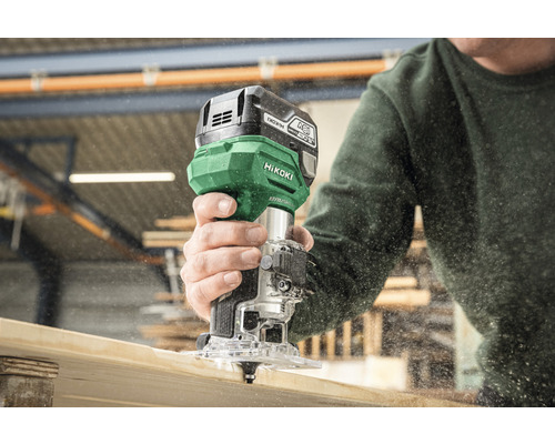 Eine Person benutzt eine Akku-Oberfräse der Marke HiKOKI zum Bearbeiten eines Holzstücks.