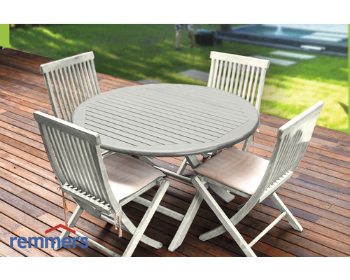 Holztisch mit vier Holzstühlen und Sitzkissen auf einer Terrasse