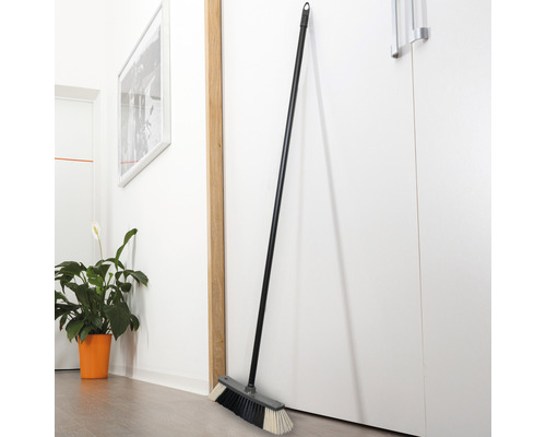Besen mit Stiel, angelehnt an einer Tür