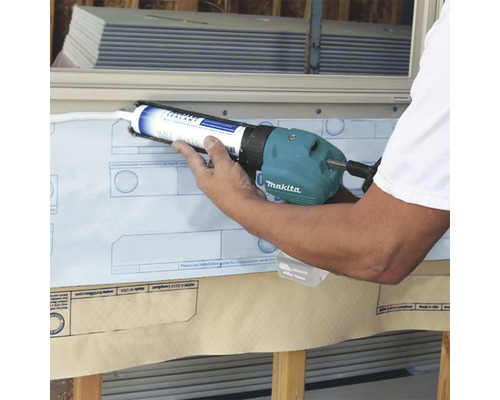 Un applicateur applique du mastic sur un mur avec un pistolet à calfeutrer. Logo Makita.