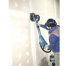 Une personne utilise une ponceuse à plafond Makita sur un mur pour le travailler.
