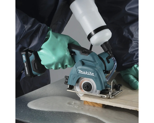 Coupe-carrelage sans fil Makita coupant un carreau avec alimentation en eau