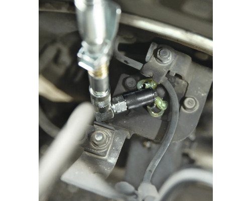 Schmiernippel mit Fettpresse an einem Maschinenteil