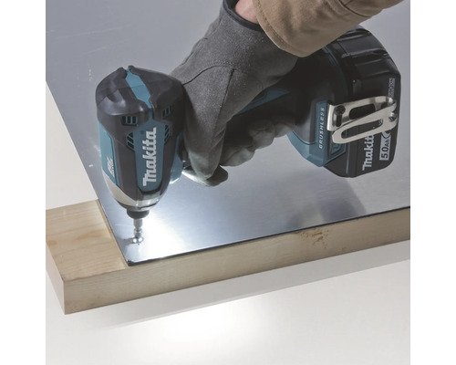 Logo Makita. Visseuse à percussion sans fil travaillant sur une pièce métallique sur une planche de bois.