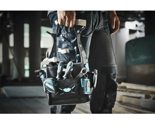 Handwerker mit Werkzeugtasche am Gürtel, gefüllt mit Hammer, Schraubendrehern und weiterem Werkzeug