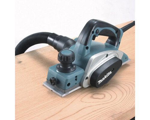 Raboteuse électrique Makita avec aspiration de poussière sur une planche de bois