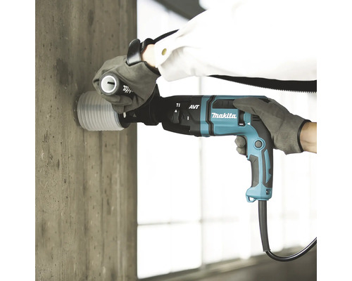 Perçage d''un mur en béton avec un perforateur burineur Makita et un dispositif d''aspiration de la poussière