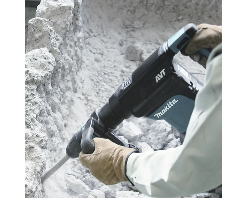 Marteau-piqueur Makita en cours d''utilisation sur un mur de pierre.