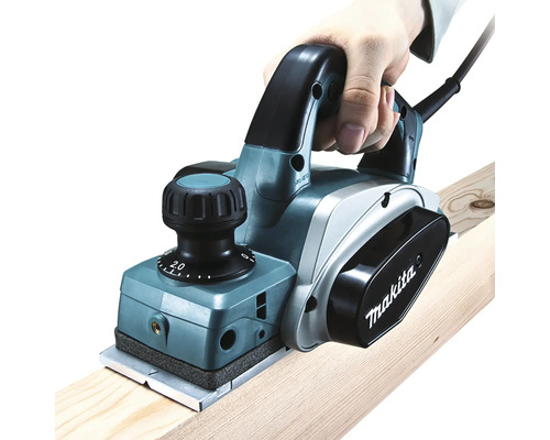 Raboteuse électrique en cours d''utilisation sur une planche de bois, marque Makita