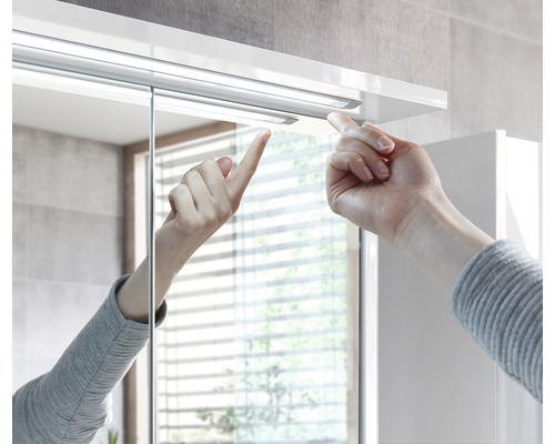 Gros plan d''une armoire de toilette avec une main touchant un mécanisme