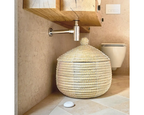 Scène de salle de bains avec meuble sous-lavabo, siphon et panier avec couvercle.