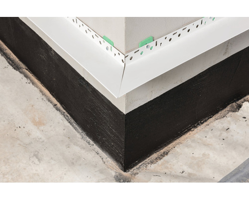 Detailansicht einer abgedichteten Gebäudeecke mit Sockelabdichtung