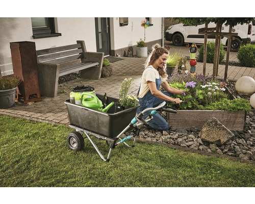 Femme travaillant dans le jardin avec une brouette et un bac à plantes